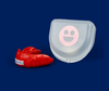 A plastic smiley face alongside a red plastic mouth guard-Cheeky