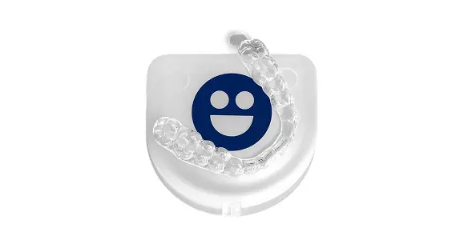 Clear dental aligner with a blue smiley face design on a white background